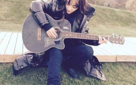 李小璐坐在地上弹吉他扮文艺青年